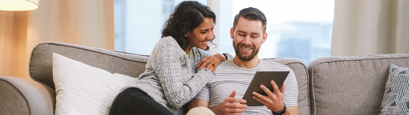 couple looking happily at tablet